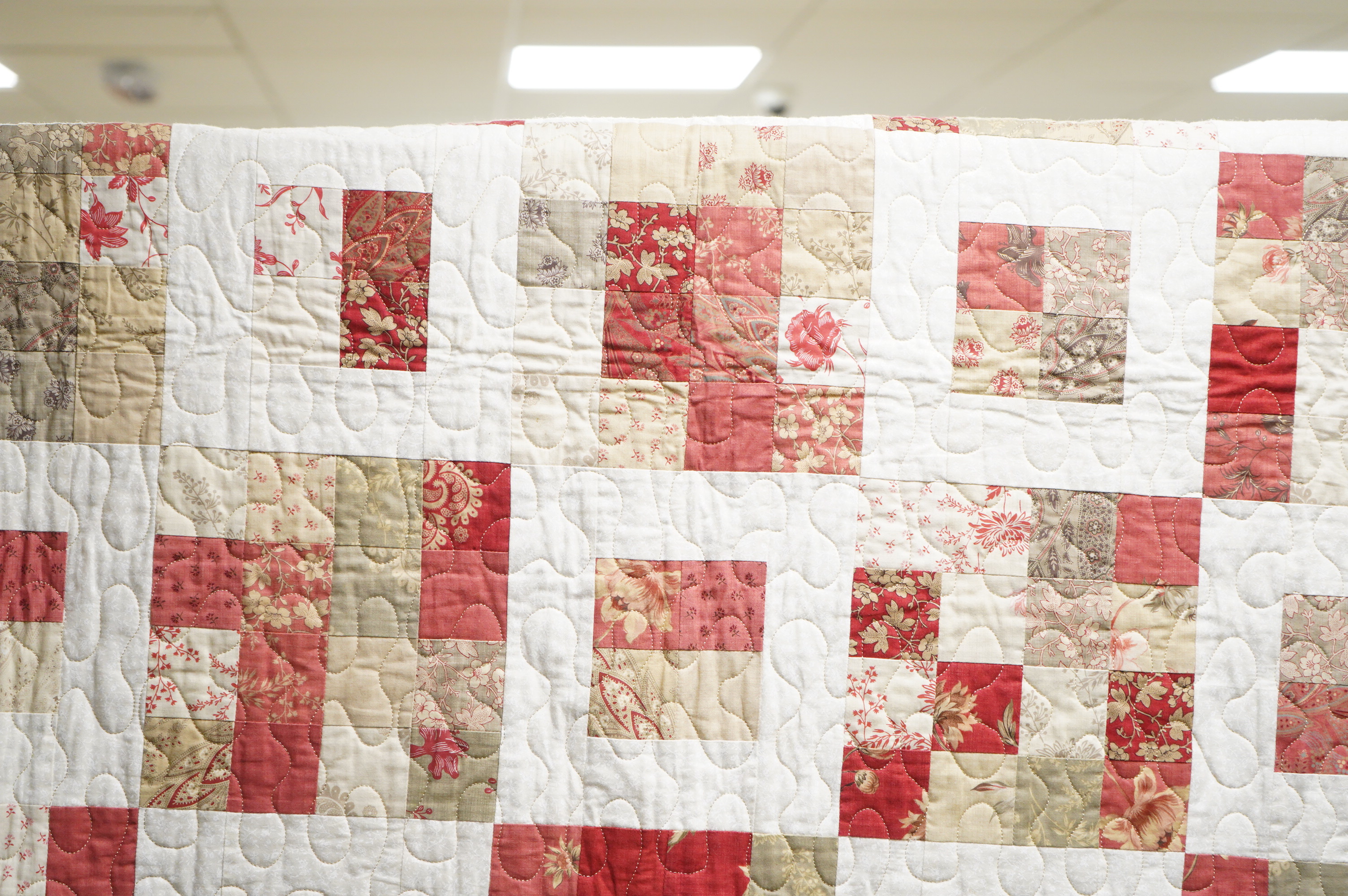 A contemporary patchwork quilt, with label: Quilts from the shed, handmade with love by Suzanne. 138cm x 136cm